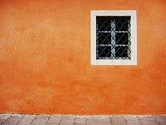 Keeping Composition Simple. An orange wall with a window in it.