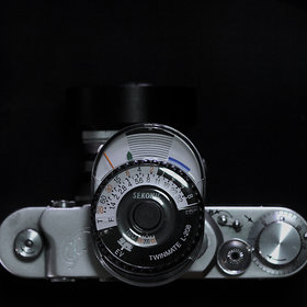 An old Sekonic L-208 Light Meter on a camera. Photo by JE Labs
