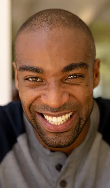 A portrait of a smiling man taken with a wide-open aperture.