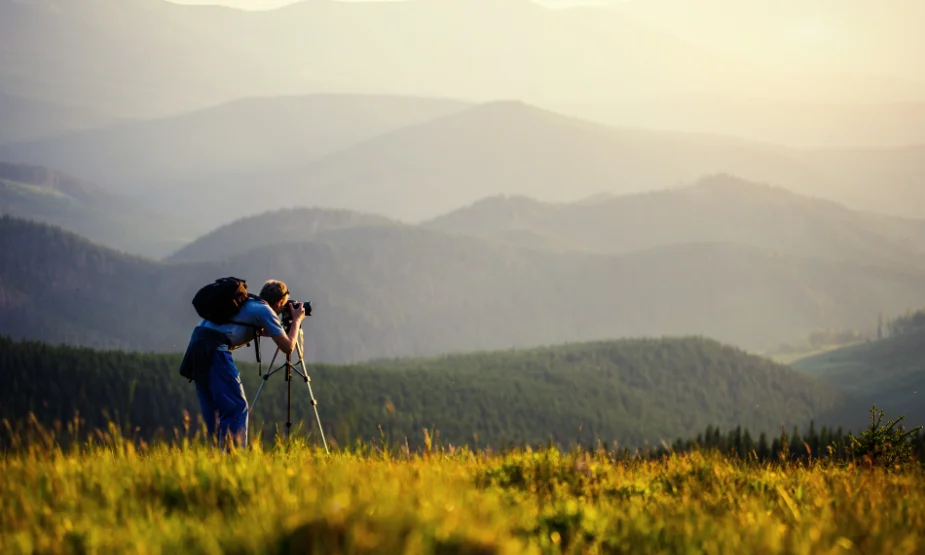 Photographer using a tripod to capture a landscape photograph