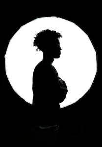 Composing a backlit image. A young man in silhouette in front of a studio light. Image by Gift Habeshaw.